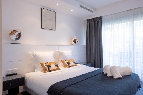 um quarto com uma cama com dois pares de sapatos em Cannes Panorama - Piscine, vue mer, parking, clim em Cannes
