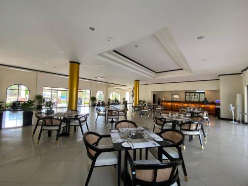 um restaurante com mesas e cadeiras num quarto em Plaza Del Norte Hotel and Convention Center em Laoag