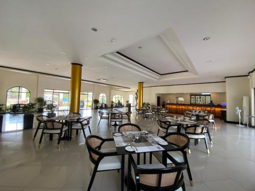 een restaurant met tafels en stoelen in een kamer bij Plaza Del Norte Hotel and Convention Center in Laoag