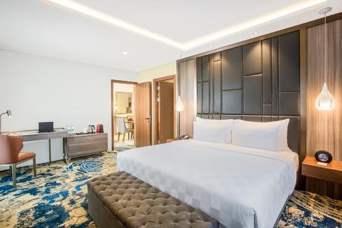 a hotel room with a large bed and a desk at Swiss-Belhotel Cendrawasih, Biak in Fandoi