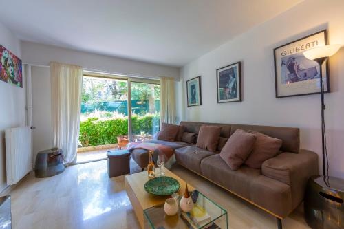 un salon avec un canapé et une table dans l'établissement Appartement Les Cyclamen - Happy Rentals, à Nice