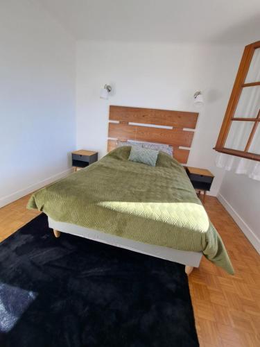 sypialnia z łóżkiem z drewnianym zagłówkiem w obiekcie T2 AVEC TERRASSE w mieście Oloron-Sainte-Marie