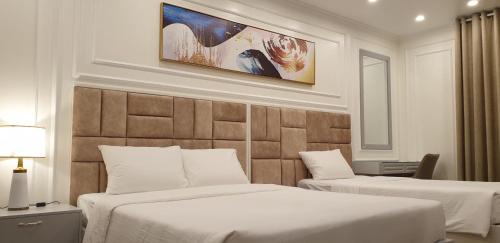 pokój hotelowy z 2 łóżkami i ścianą w obiekcie Gia Hưng Khang Hometel w Ha Long