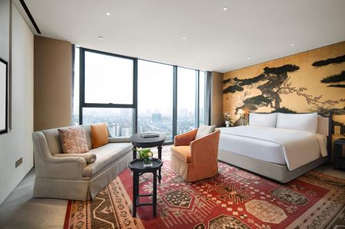 a hotel room with a large bed and a couch at Mumian Chengdu, in The Unbound Collection by Hyatt in Chengdu