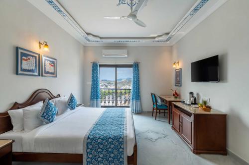 um quarto de hotel com uma cama, uma secretária e uma janela em Maan Vilas By Stone Wood em Udaipur