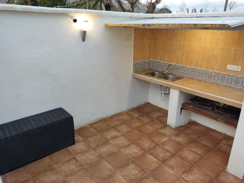 een kleine keuken met een aanrecht en een wastafel bij Alojamiento entero: chalet. in Alicante
