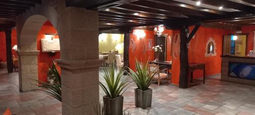a lobby with two potted plants in a room at La Casona de Revolgo in Santillana del Mar
