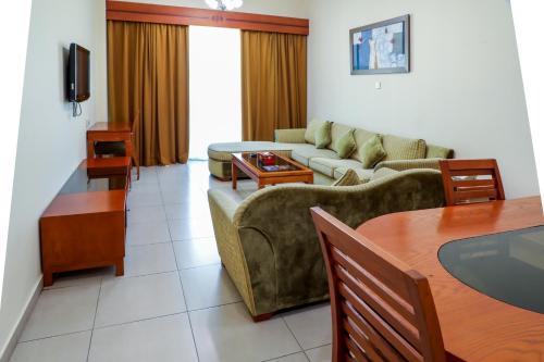 ein Wohnzimmer mit einem Sofa und einem Tisch in der Unterkunft West Zone Plaza Hotel Apartment (Formerly Winchester Hotel Apts) in Dubai