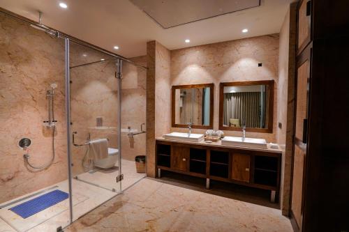 uma casa de banho com 2 lavatórios e um chuveiro em Pushkara Resort and Spa, Pushkar em Pushkar