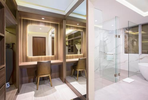 a bathroom with a vanity and a shower and a sink at Swiss-Belhotel Cendrawasih, Biak in Fandoi