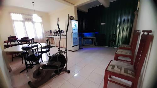 uma sala de estar com uma televisão e uma mesa e cadeiras em Madara Hotel em Horana