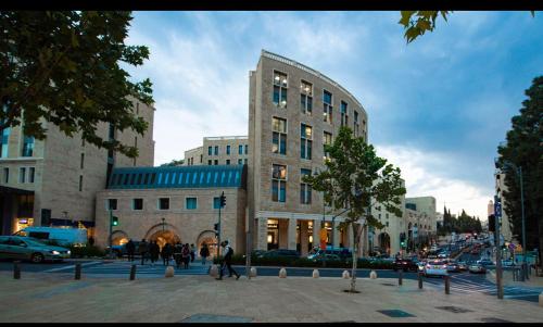 a building on a city street with people walking in front of it at The MAZ Jerusalem in Jerusalem