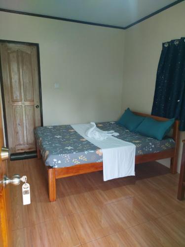 a small bed in a room with a door at Gardenview Homestay Siargao in General Luna