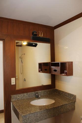 a bathroom with a sink and a mirror at Talya Patong Hotel in Patong Beach
