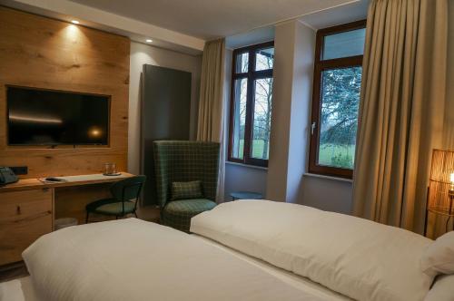a hotel room with a bed and a desk and window at Landhaus Klosterwald in Lich