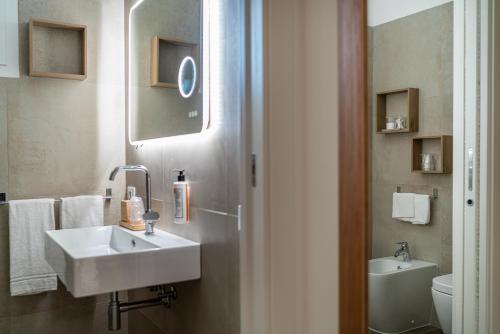 a bathroom with a sink and a toilet at Hotel Atlantic in Lignano Sabbiadoro