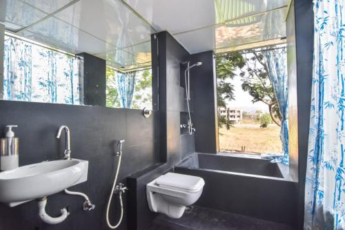 a bathroom with a sink and a toilet and a tub at Dev1villa in Lonavala