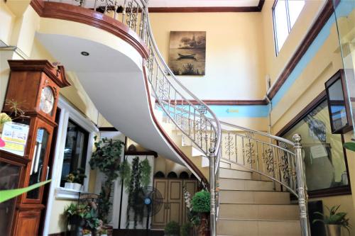 a spiral staircase in a house with plants at PALM TREE RESORT AND RESTAURANT in Olongapo