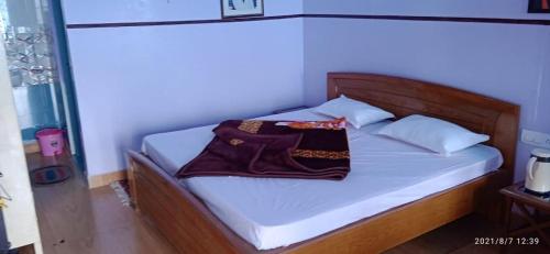 a bed with a wooden headboard with two bags on it at Aasara HomeStay Soli Kausani in Kausani