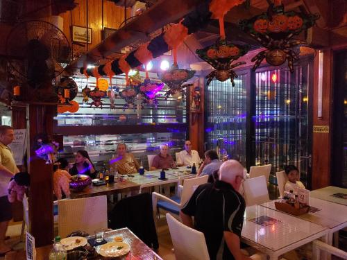 a group of people sitting at tables in a restaurant at PALM TREE RESORT AND RESTAURANT in Olongapo