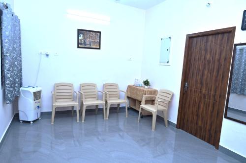 a waiting room with chairs and a table and a door at VINNEST in Tiruchchirāppalli