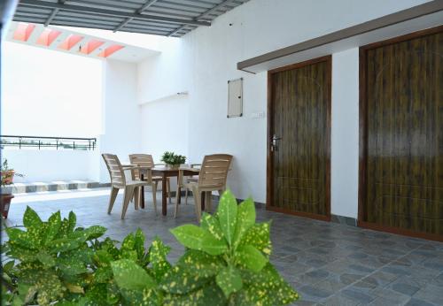 a dining room with a table and chairs and a door at VINNEST in Tiruchchirāppalli