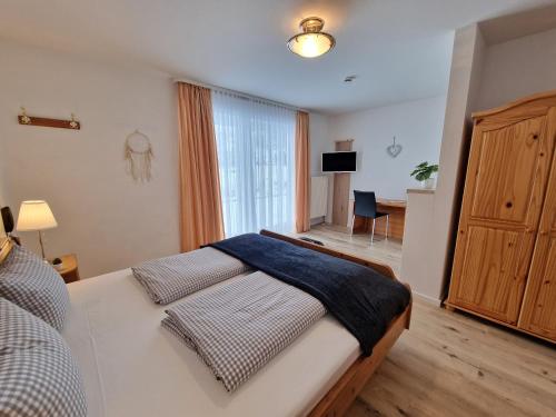 ein Schlafzimmer mit einem großen Bett und einem großen Fenster in der Unterkunft HoFer am Zeitberg Ferienwohnung Lindenbach in Bad Kohlgrub