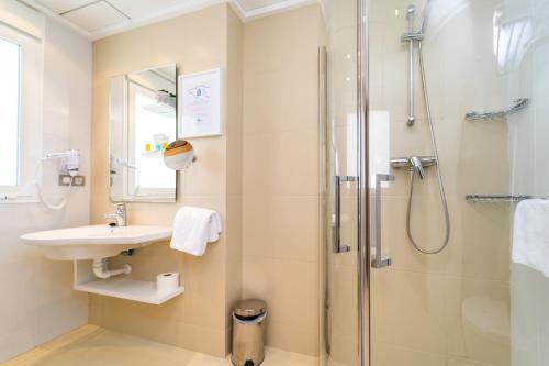 a bathroom with a sink and a shower at Hotel Vistamar Wellness by DLV in Villajoyosa