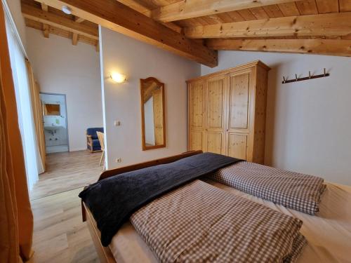 1 dormitorio con 1 cama en una habitación con techos de madera en HoFer am Zeitberg Ferienwohnung Falleralm en Bad Kohlgrub