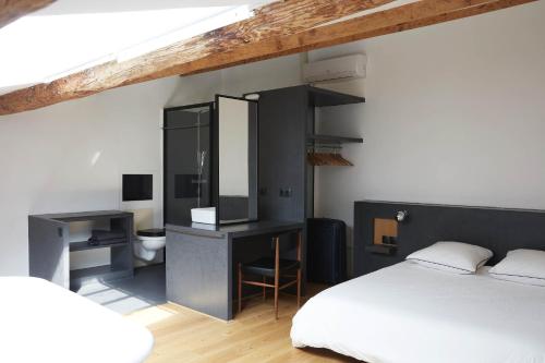 une chambre avec un lit et un bureau et une salle de bain dans l'établissement LOFT D'ARCHITECTE SUR LE VIEUX PORT, à Marseille