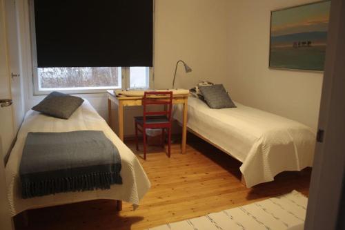 1 Schlafzimmer mit 2 Betten, einem Schreibtisch und einem Stuhl in der Unterkunft Cozy Summerhouse by the River in Rovaniemi