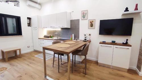 una cucina con tavolo, lavandino e TV di Marina Apartments a Catanzaro Lido