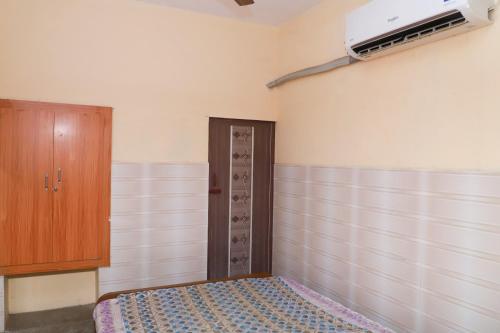 ein leeres Zimmer mit einem Bett und einem Schrank in der Unterkunft AMMAN LODGE in Tiruchchirāppalli