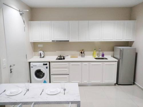 uma cozinha com armários brancos e um frigorífico em Luxury Blue Paris Suite # I-City # Free Wifi + Free Parking [1r1b] em Shah Alam