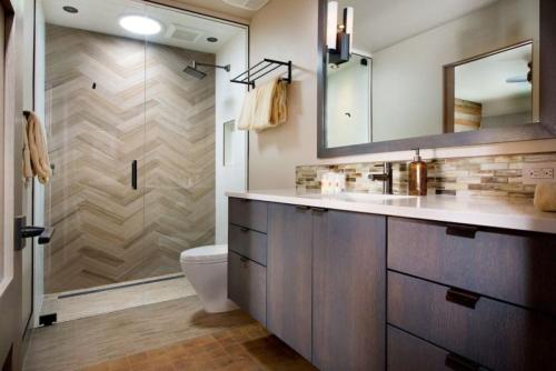 y baño con aseo, lavabo y ducha. en Luxury 3 Bedroom Downtown Aspen Vacation Rental With Amenities Including Heated Pool, Hot Tubs, Game Room And Spa en Aspen