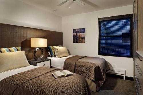 um quarto de hotel com duas camas e uma janela em Luxury 3 Bedroom Downtown Aspen Vacation Rental With Amenities Including Heated Pool, Hot Tubs, Game Room And Spa em Aspen