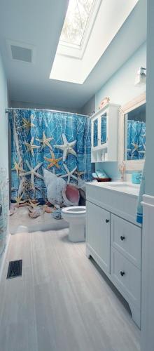 a bathroom with a sink and a toilet and a window at Boho Cottage - Hot tub and close to Beach in Fort Erie