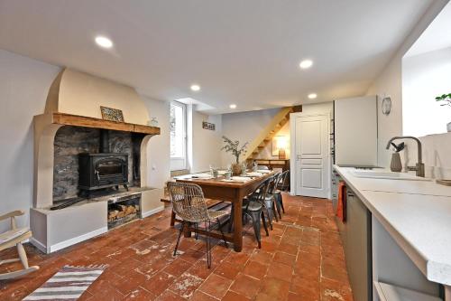 a kitchen and dining room with a table and a fireplace at Le Mas des Rouquets - avec piscine et jardin in Anduze