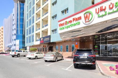 um parque de estacionamento com carros estacionados em frente a um edifício em West Zone Plaza Hotel Apartment (Formerly Winchester Hotel Apts) em Dubai