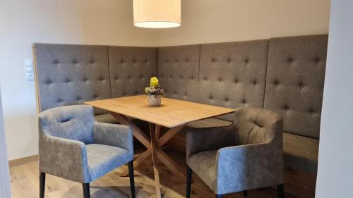 a dining room with a wooden table and blue chairs at Landhotel Lechner Appartements in Kirchberg in Tirol