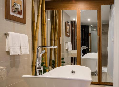 a bathroom with a white tub and a sink at An Vista Hotel in Nha Trang