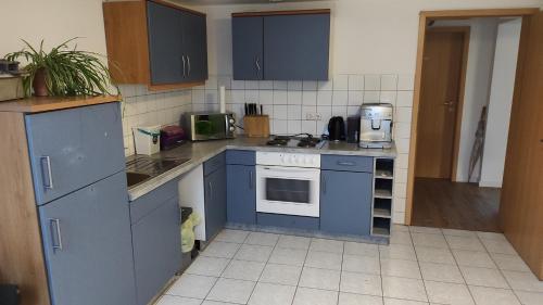 a kitchen with blue cabinets and a stove top oven at Zimmervermietung M.P. in Greiz