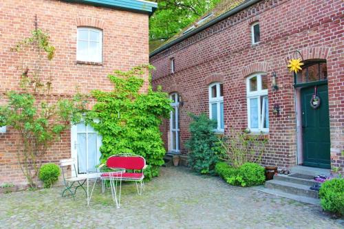 a brick house with a table and chairs in front of it at Romantische Ferienwohnung Unter den Linden in Buchholz