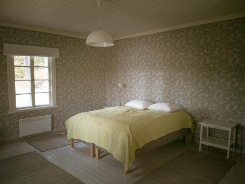 - une chambre avec un lit et une couverture jaune dans l'établissement Vilkman of UNESCO World Heritage Site Verla, à Kouvola