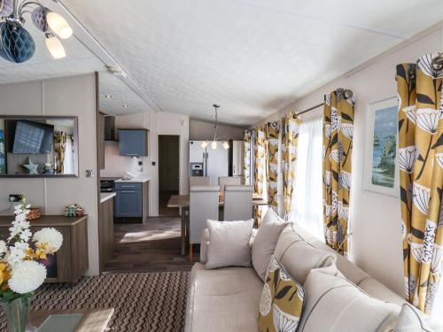 a living room with a couch and a kitchen at The Rodley Pines in Scarborough