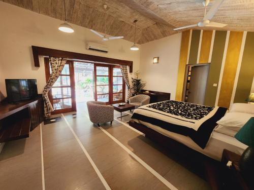 a bedroom with a bed and a desk and a television at Casa Vagator in Vagator