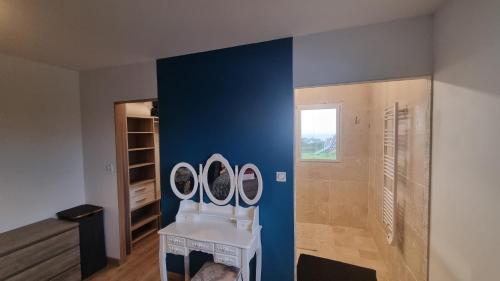 a bathroom with a blue wall and a sink at Maison 3 chambres vue mer et phare in Plouarzel