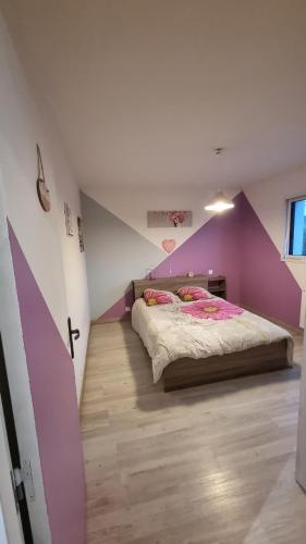 a bedroom with a bed with a purple wall at Maison 3 chambres vue mer et phare in Plouarzel