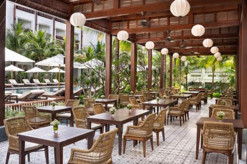 ムイネーにあるThe Anam Mui Neのテーブルと椅子のあるレストラン、プールを提供しています。