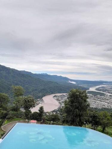 a swimming pool with a view of a river and mountains at A Majestic Luxurious Villa Overlooking The Ganges in Rishīkesh